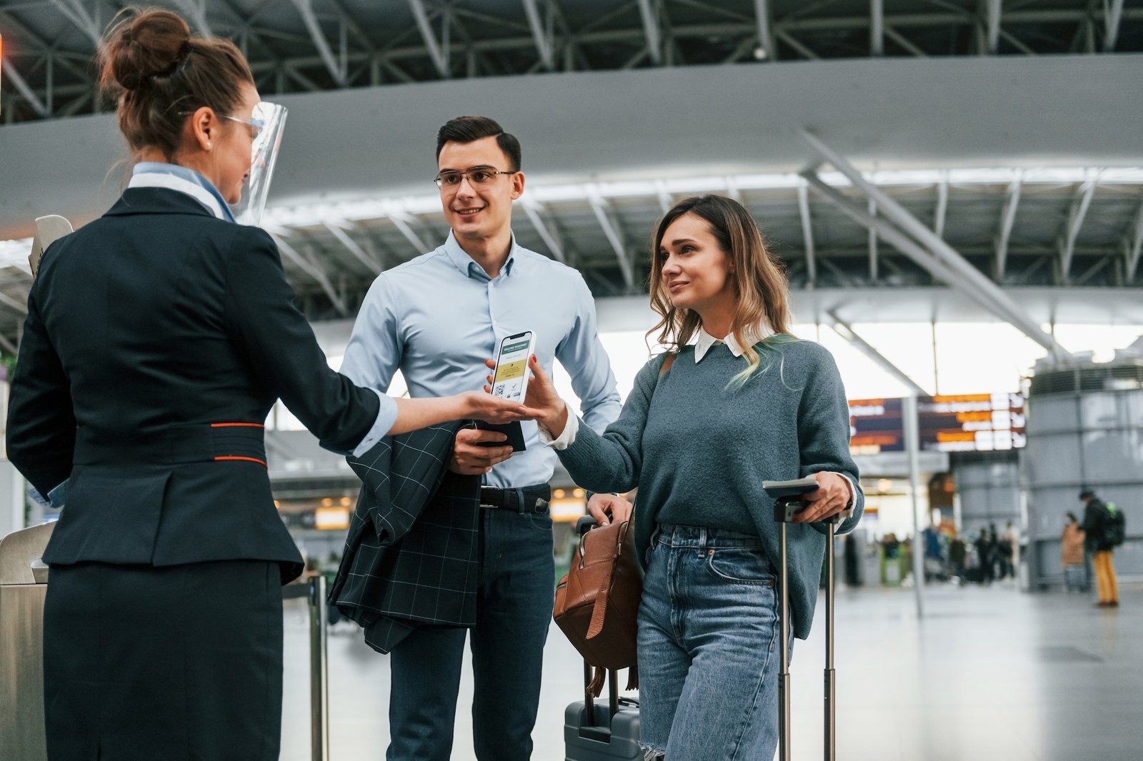 Showing vaccination certificate. Young couple is in the airport together