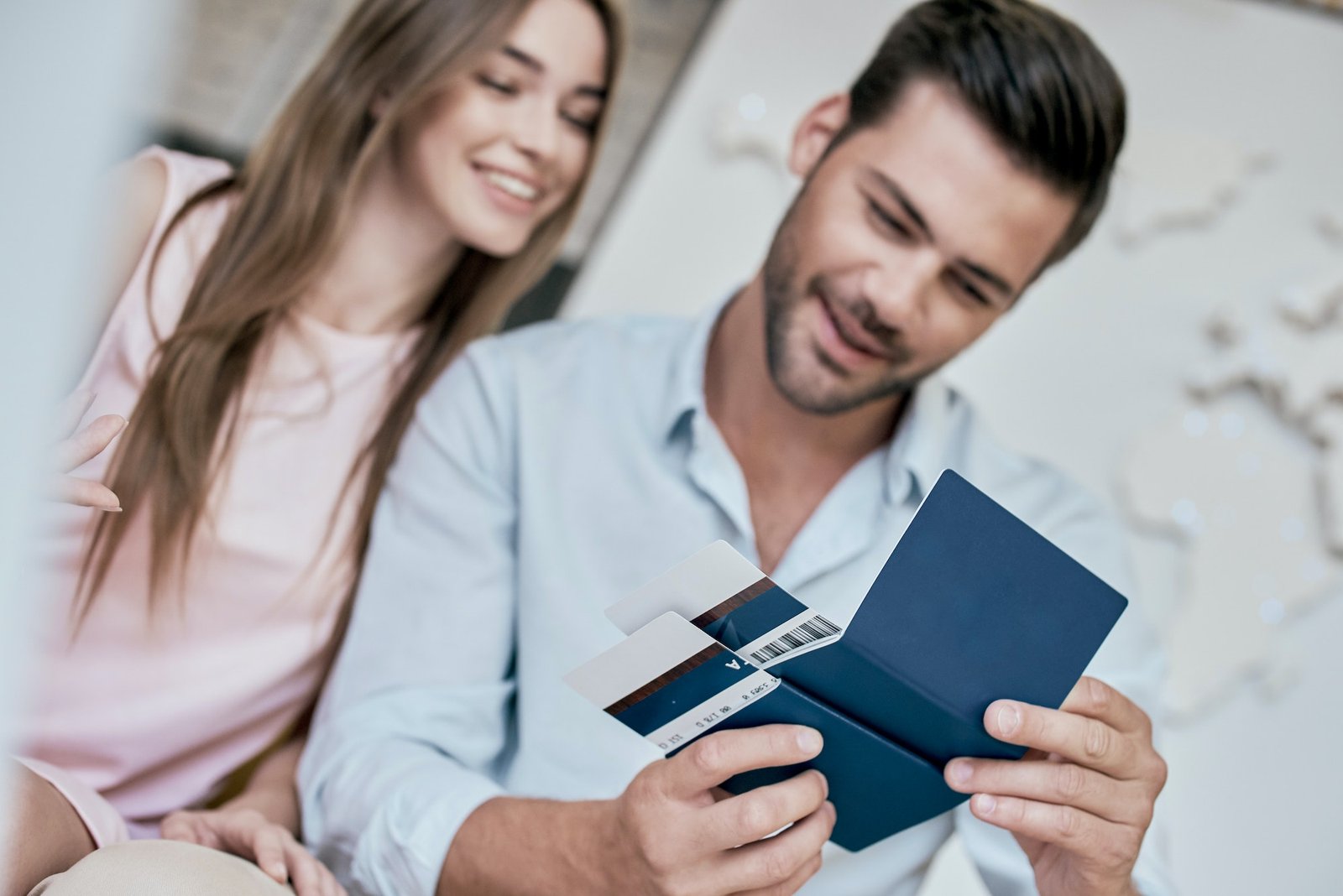 Young man smiling and reviwing tickets, passport with visa