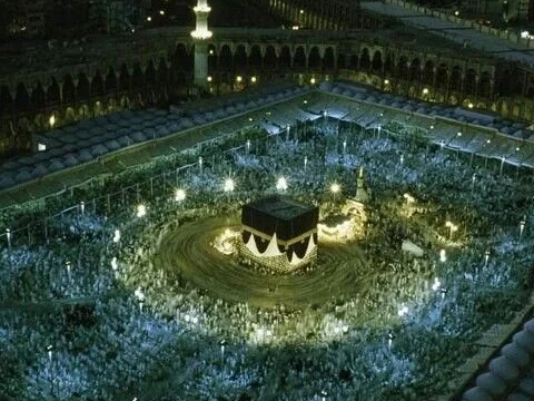 "A pilgrim praying at the Kaaba during Hajj",